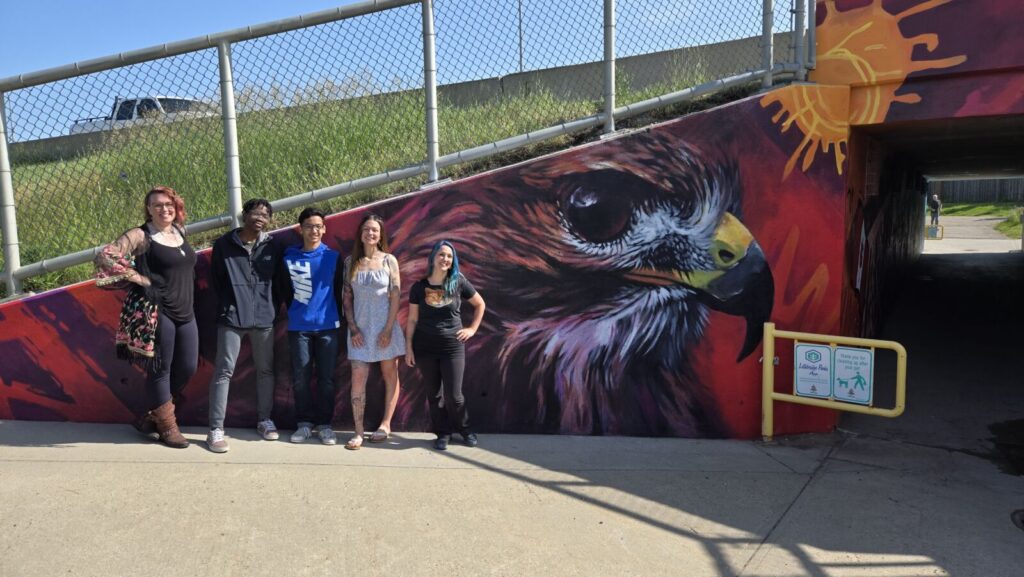 L to R: Layla Folkmann, Lolu Awoderu, Wesley Vizcrra, Lacey Jane Wilburn, and Leanne Kembel at the mural unveiling on June 13, 2025. (Photo: J. Goulet, My Lethbridge Now)